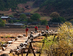 学生走过用木头支撑的简易小桥