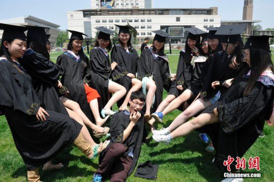 大学生拍个性毕业照致青春:众美女露大腿踩男生